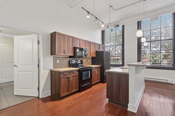 A kitchen with brown cabinets, a dishwasher, and a white island.